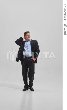 Businessman in open jacket posing with confidence and relaxed energy Businessman in open jacket posing with confidence and relaxed energy 130620375
