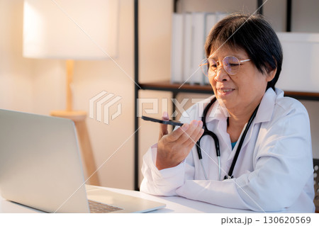 Senior asian doctor using voice assistant with AI artificial intelligence on smartphone. Senior asian doctor using voice assistant with AI artificial intelligence on smartphone. 130620569