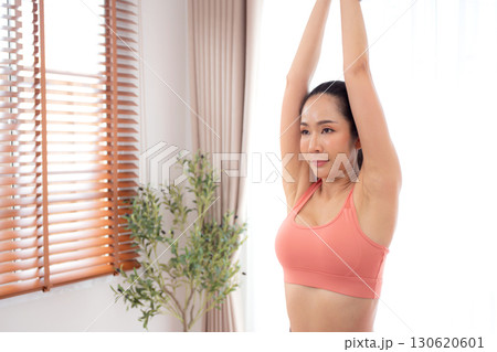 Young asian woman in activewear yoga pose on mat with meditation in living room at home. 130620601