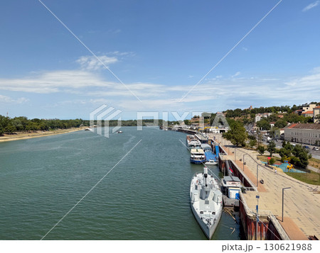 Danube river with docked ship and moored vessels along Belgrade quay under clear summer sky. Urban landscape, transport, shipping, economy, navigation, tourism, recreation, cultural heritage and 130621988