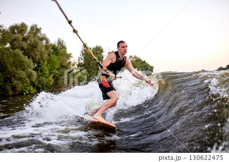 Man wakeboarding on a river during a beautiful afternoon 130622475