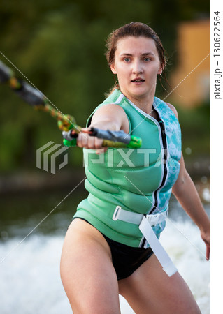 Young woman engaged in an exciting water sports activity 130622564