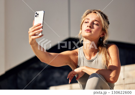 Young woman taking a selfie outdoors in natural lighting 130622600