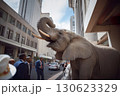 A large elephant in business district of city surrounded by people on street 130623329