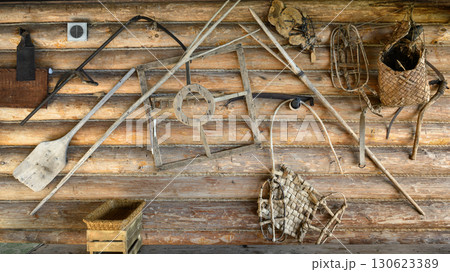 Old rustic wooden tools and gear on log cabin wall by White Sea in Russian Karelia, vintage and culture concept 130623389