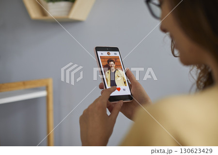 Young woman using dating app on mobile phone Young woman using dating app on mobile phone 130623429