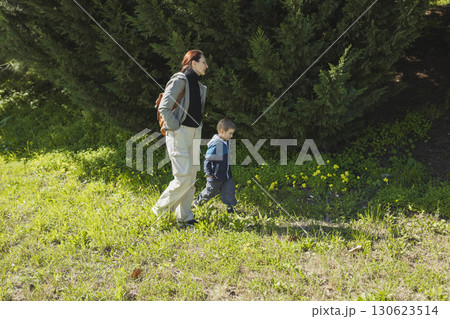 Mother and son walking in park enjoying sunny day Mother and son walking in park enjoying sunny day 130623514