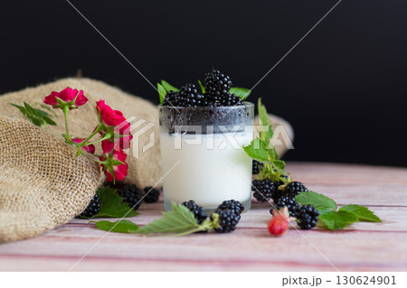 Natural yogurt with blackberries and fresh leaves 130624901