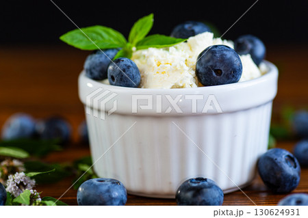 Light protein dessert cottage cheese with blueberries on a wooden table 130624931