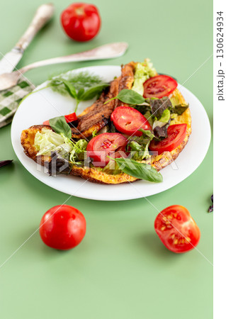 Golden omelette with salad mix and spicy aroma on top 130624934