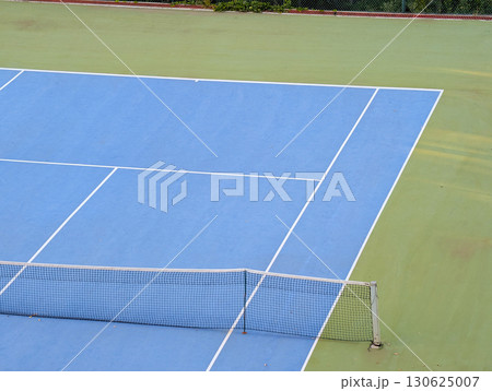 Blue and green tennis court with white lines and net. Sports tourism in mountain village. Blue and green tennis court with white lines and net. Sports tourism in mountain village. 130625007