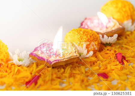 Diwali Festival. Lit oil lamps with marigold flowers and decorative petals. Diwali Festival. Lit oil lamps with marigold flowers and decorative petals. 130625381