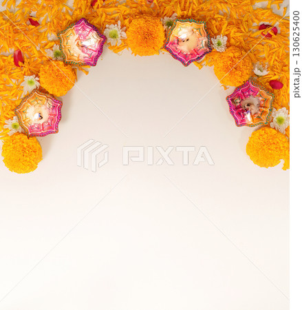 Diwali Decor. Colorful diyas and marigold flowers arranged in a festive arch. Diwali Decor. Colorful diyas and marigold flowers arranged in a festive arch. 130625400