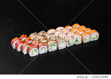 Delicious sushi rolls set displayed on black background Delicious sushi rolls set displayed on black background 130625990