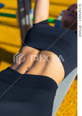 Fit woman performing outdoor workout on a sunny day Fit woman performing outdoor workout on a sunny day 130626178