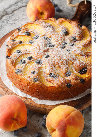 Blueberry Peach Sour Cream Cake with fresh summer fruit closeup on the wooden board. Vertical Blueberry Peach Sour Cream Cake with fresh summer fruit closeup on the wooden board. Vertical 130626217