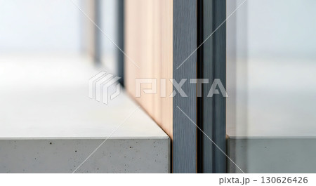 Minimalist architectural detail with intersecting concrete surfaces and a glass panel. Clean lines emphasize the modern design. Soft lighting enhances the sleek composition 130626426