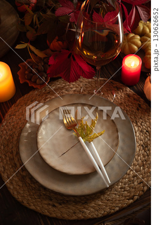 Autumn Table Setting with Plates, Wine, Pumpkins and Seasonal Decor Autumn Table Setting with Plates, Wine, Pumpkins and Seasonal Decor 130626652