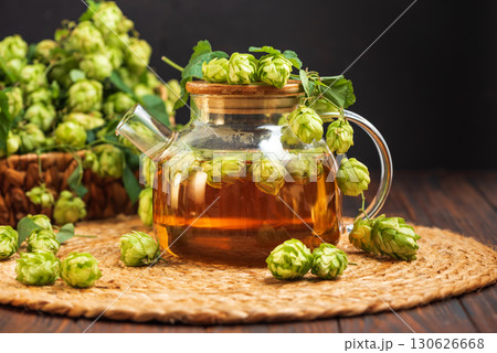 Hop Tea with Fresh Hops in Glass Teapot on Rustic Background Hop Tea with Fresh Hops in Glass Teapot on Rustic Background 130626668