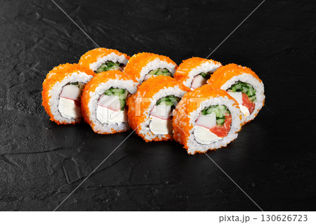 California uramaki rolls covered with tobiko flying fish roe lying on black slate surface California uramaki rolls covered with tobiko flying fish roe lying on black slate surface 130626723
