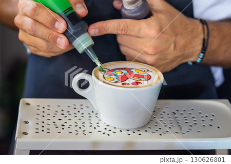 Barista creating colorful latte art with bright patterns on cappuccino foam using liquid food colors. Concept of creative coffee, barista skills, artistic drink preparation 130626801