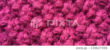 Knitted woolen fabric pattern in rich magenta. Macro texture of a cozy sweater, thick woven yarn 130627308