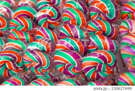 Color lollipop, spiral candy on stick, colorful striped lollypop, round fruit caramel, multicolored confectionery 130627499