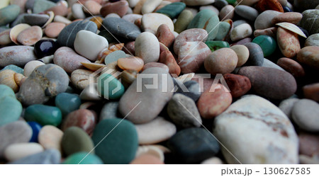 Colorful smooth quartz stones on round pebbles mixed with small sea shells close up angle view Colorful smooth quartz stones on round pebbles mixed with small sea shells close up angle view 130627585