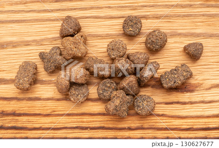 Dry pet food macro pieces, cat kibble closeup, dog pellets, small protein croquettes detailed Dry pet food macro pieces, cat kibble closeup, dog pellets, small protein croquettes detailed 130627677