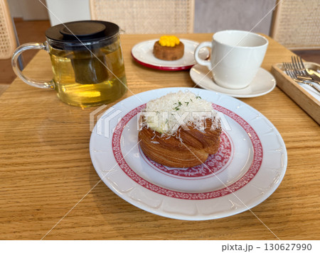 Shepherd's pie with grated cheese served on patterned plate with tea. Dining lifestyle, bakery culture and gastronomy with refreshment, leisure and culinary indulgence. 130627990