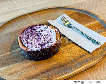 Berry cheesecake placed on wooden tray with fork and napkin. Sweetness, indulgence, lifestyle and gastronomy with dessert culture and culinary presentation. 130628010