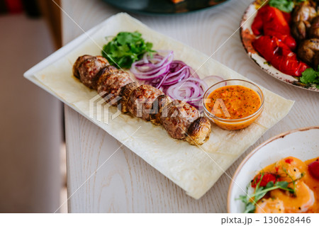 Grilled meat and mushrooms on lavash with onion, cilantro and spicy red pepper sauce Grilled meat and mushrooms on lavash with onion, cilantro and spicy red pepper sauce 130628446