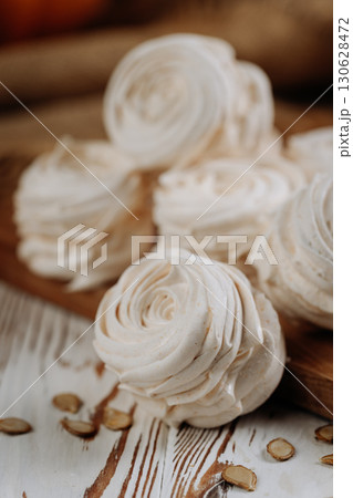 Homemade pumpkin marshmallows on rustic wooden table with seeds and autumn decor Homemade pumpkin marshmallows on rustic wooden table with seeds and autumn decor 130628472