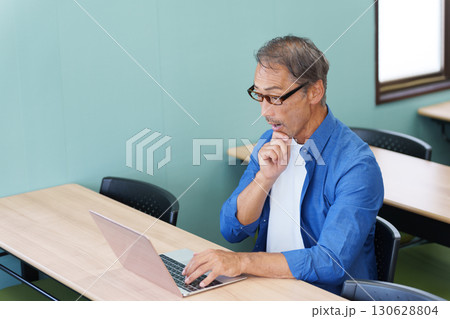 パソコンを使い驚くシニア男性 130628804
