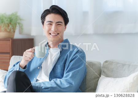 家で飲み物を飲む男性 130628828