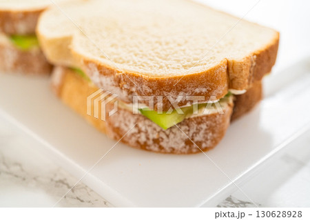 Soft sandwich bread layered with a savory cream cheese mixture and crisp cucumber slices, assembled into mini sandwiches. Ideal for tea parties, bridal showers, or elegant brunch spreads. 130628928
