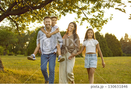 Happy mom, dad and children enjoying summer and walking together in beautiful green park Happy mom, dad and children enjoying summer and walking together in beautiful green park 130631846