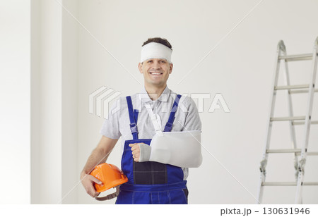Happy builder with an arm in a cast and a helmet in his hands, front view Happy builder with an arm in a cast and a helmet in his hands, front view 130631946