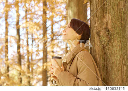 紅葉の中をコーヒーを飲む女性 ミドルエイジ 紅葉の中をコーヒーを飲む女性 ミドルエイジ 130632145