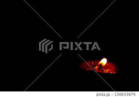 Burning Clay Oil Lamp in Darkness Symbolizing Light and Hope 130633674