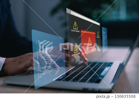 Hands typing on laptop with digital system warning alert on virtual screen, concept of cybersecurity threat, data breach, malware, coding error, online risk, computer failure and IT protection. 130635508