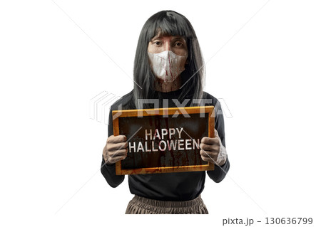 Indonesian southeast asian transgender man dressed as a woman wearing a bloody face mask and showing the text of Happy Halloween on a blackboard. Concept of Halloween, Sister Hong, or red uncle Indonesian southeast asian transgender man dressed as a woman wearing a bloody face mask and showing the text of Happy Halloween on a blackboard. Concept of Halloween, Sister Hong, or red uncle 130636799