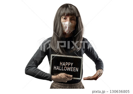 Indonesian southeast asian transgender man dressed as a woman wearing a bloody face mask and showing the text of Happy Halloween on a tablet screen. Concept of Halloween, Sister Hong, or red uncle Indonesian southeast asian transgender man dressed as a woman wearing a bloody face mask and showing the text of Happy Halloween on a tablet screen. Concept of Halloween, Sister Hong, or red uncle 130636805