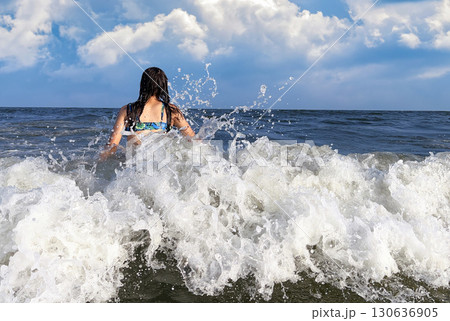 Happy teenager enjoying the ocean waves 130636905