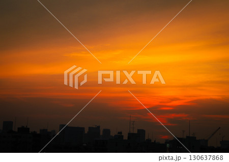 真っ赤に染まる夕焼け空と都市のシルエット 130637868