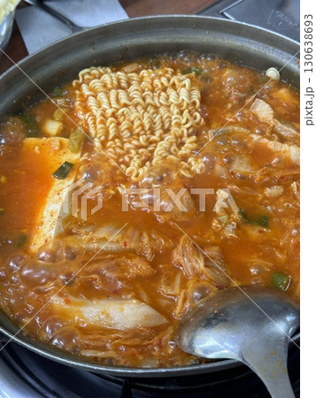 A hearty bowl of Budaejjigae (Korean Army Stew), filled with sausage, tofu, kimchi, and noodles in a spicy broth. This flavorful dish brings warmth and comfort, perfect for sharing. A hearty bowl of Budaejjigae (Korean Army Stew), filled with sausage, tofu, kimchi, and noodles in a spicy broth. This flavorful dish brings warmth and comfort, perfect for sharing. 130638693