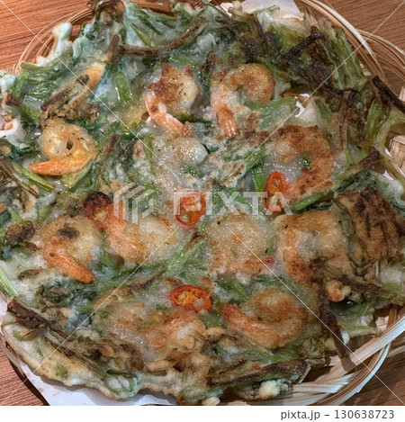 Korean savory pancake (Pajeon) with green onions and vegetables, crispy on the edges and tender inside. A popular Korean dish enjoyed with dipping sauce, perfect as a snack or appetizer. 130638723