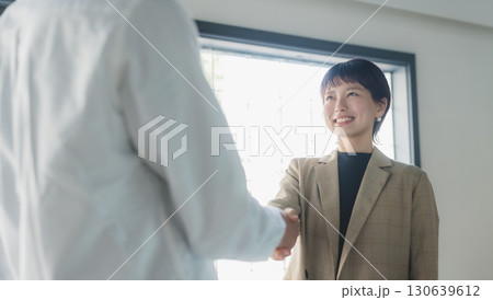 仲間と握手する女性 130639612