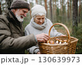 Senior couple enjoying mushroom picking in an autumn forest, holding a wicker basket full of freshly foraged mushrooms, dressed warmly for a cozy outdoor activity together Senior couple enjoying mushroom picking in an autumn forest, holding a wicker basket full of freshly foraged mushrooms, dressed warmly for a cozy outdoor activity together 130639973