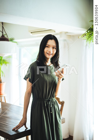 　窓際でスマホを見る女性 130639984